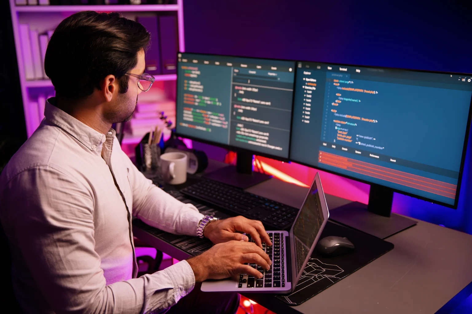 Developer working across multiple monitors with code on screen